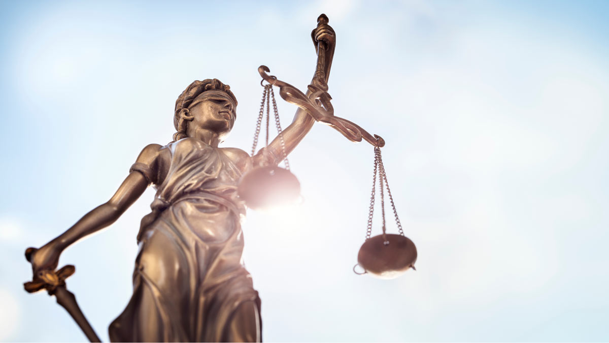 Justitia, die römische Göttin der Gerechtigkeit. In der einen Hand hält Justitia eine Waagschale, in der anderen ein Schwert. Außerdem kann sie nichts sehen, denn sie hat die Augen verbunden.