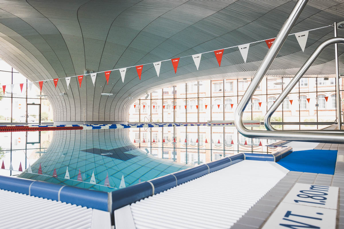 Innenansicht der Schwimmhalle Ilmenau mit Schwimmbecken und Deckenkonstruktion