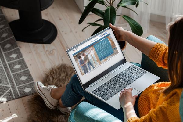 junge dunkelhaarige Frau sitzt am Laptop und informiert sich auf der Website des TMDI