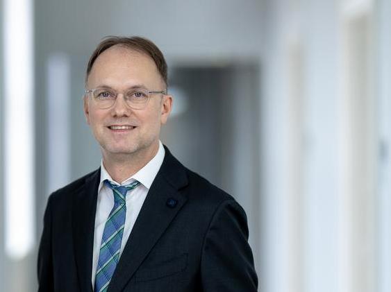 Staatssekretär Dr. Tobias J. Knoblich steht vor dem Gebäude des TMDI