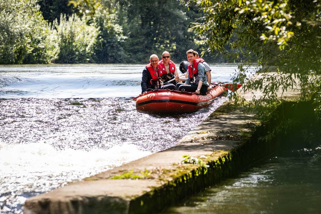 Staatsekretär Weil passiert eine Bootsrutsche auf der Saale in einem Schlauchboot der Feuerwehr Kahla