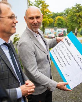 Staatssekretär Dr. Tobias J. Knoblich übergibt feierlich den Scheck für die energetische Sanierung des Schützenhauses in Stadtroda
