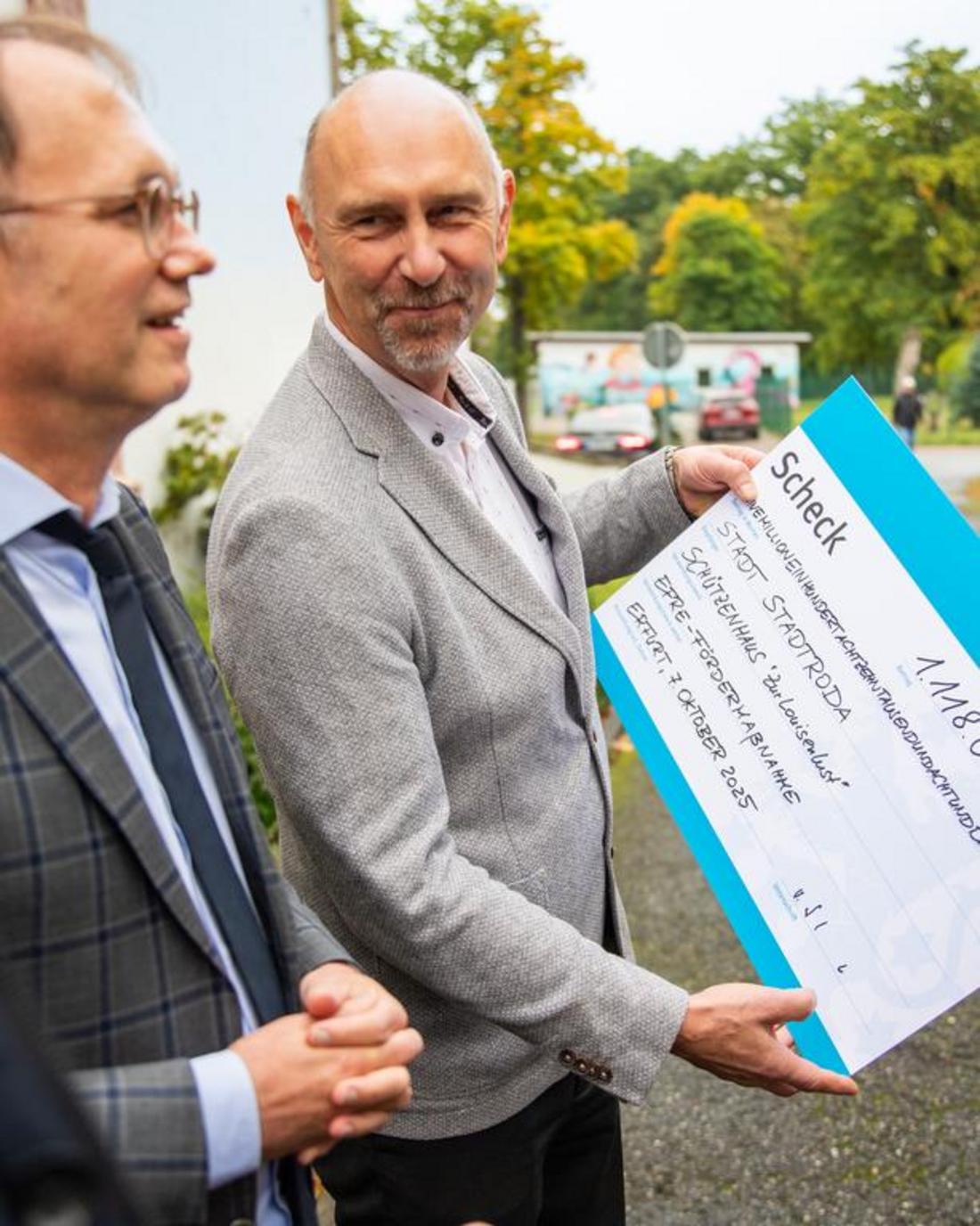 Staatssekretär Dr. Tobias J. Knoblich übergibt feierlich den Scheck für die energetische Sanierung des Schützenhauses in Stadtroda