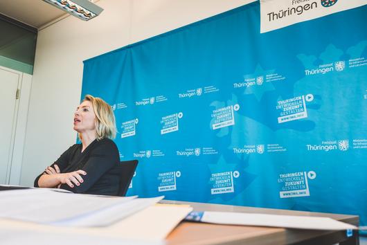 Ministerin Susanna Karawanskij vor einem blauen Hintergrund
