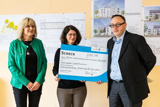Bürgermeisterin Kathrin Kräupner, Staatssekretärin Prof. Dr. Barbara Schönig und VG-Gemeinschaftsvorsitzender Ulf Ryschka halten den symbolischen Scheck über rund 2,9 Millionen Euro