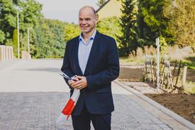 Staatssekretär Torsten Weil mit Schere und Teil des Absperrbandes