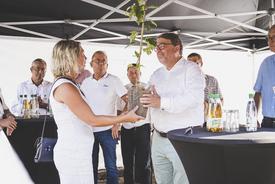 Ministerin Karawanskij übergibt dem Geschäftsführer von Wiegand-Glas einen jungen Elsbeerenbaum