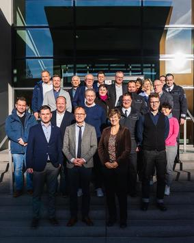 Der Thüringer Verkehrssicherheitsrat hat sich zahlreich vor dem Ministerium für Digitales und Infrastruktur versammelt. Ca 25 Personen stehen auf der Treppe und lächeln freundlich in die Kamera