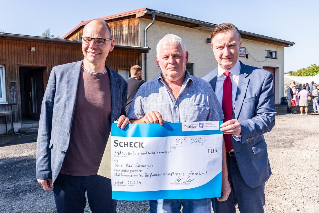 Staatssekretär Torsten Weil übergibt einen symbolischen über 874.000 € an den Ortsteilbürgermeister von Hämbach Birk Wanderer und Bad Salzungens Klaus Bohl