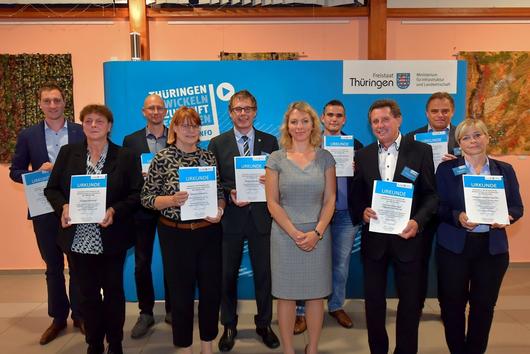 Die Empfänger:innen der Urkunden auf einem Gruppenfoto mit der Ministerin