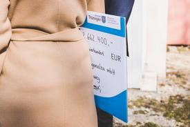 Ministerin Karawanskij hat den symbolischen Scheck unter den Arm geklemmt