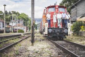 Ministerin Karawanskij, Nikolaus Wiegand und weitere Personen stehen auf einer Diesellok