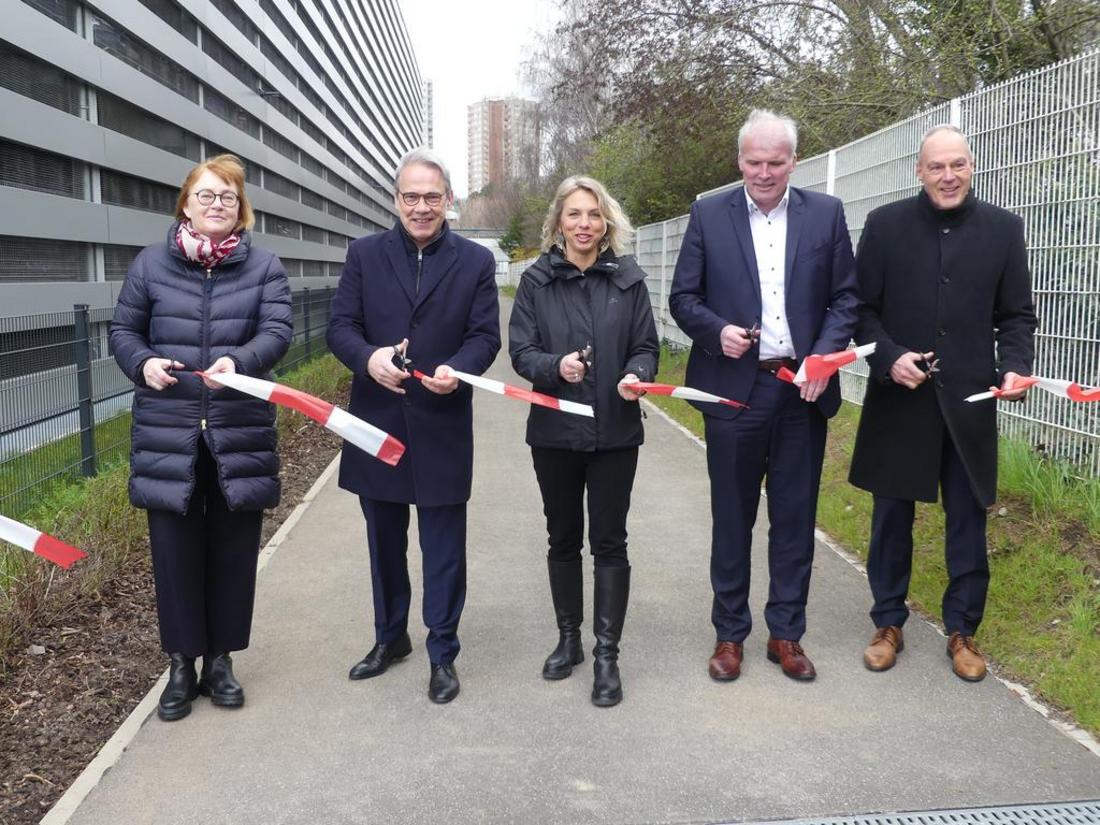 Symbolische Eröffnugn eines neuen Radweges. Fünf Personen haben ein Absperrband durchschnitten und schauen in die Kamera.