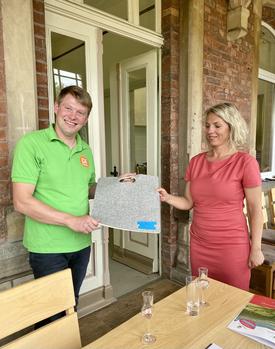Die Ministerin überreicht das Gastgeschenk (Sitzkissen aus Schafswolle) an die Saftkelterei Donndorf. | Foto: D. Kehrberg (TMIL)