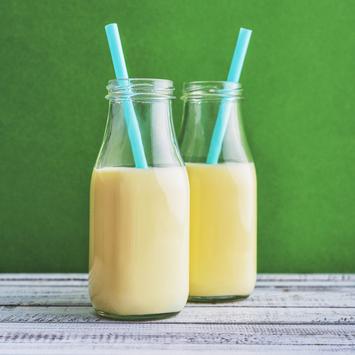 Zwei Milchflaschen mit Trinkhalmen