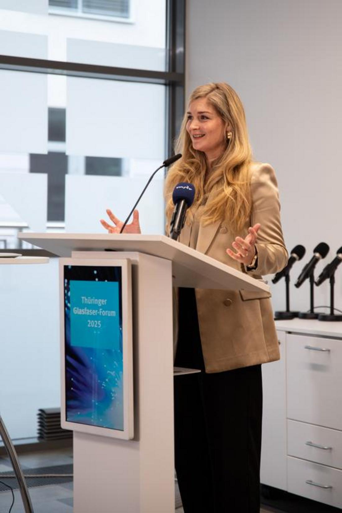 Staatssekretärin Milen Starke steht während dem Thüringer Glasfaserforum an einem Rednerpult und hält eine Rede