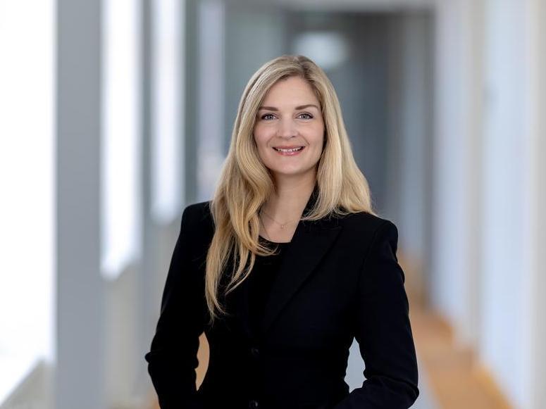 Portraitfoto, Staatssekretärin Milen Starke lächelt freundlich in die Kamera. Sie hat lange blonde Haare und trägt über einer schwarzen Bluse einen schwarzen Blazer.