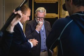 Minister Hoff riecht an einer gelagerten Knoblauchknolle