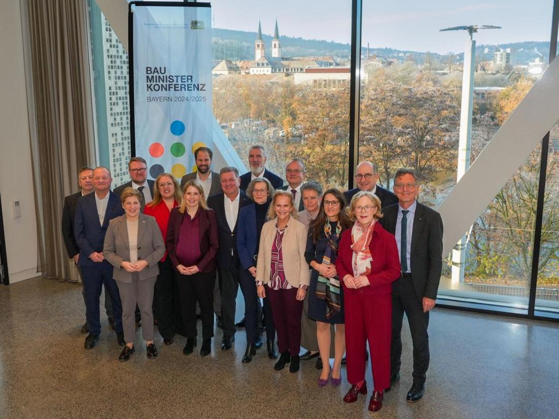 Die Teilnehmerinnen und Teilnehmer der 147. Bauministerkonferenz in Würzburg stehen beisammen und schauen freundlich in die Kamera