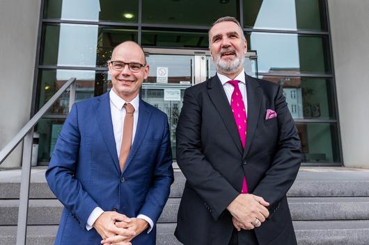Staatssekretär Torsten Weil und Minister Steffen Schütz stehen gemeinsam auf den Stufen vor dem Ministerium
