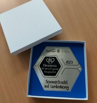 Edelstahlplakette in Wabenform in weißer Schachtel