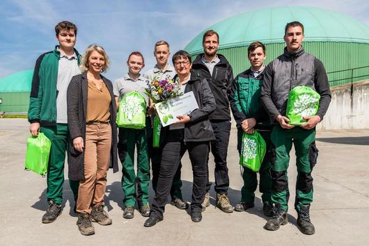 Ministerin Karawanskij, Geschäftsführerin Löhle und Azubis mit Auszeichnung auf dem Hofgelände der Agrargenossenschaft