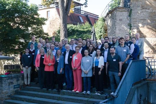 viele Teilnehmer des openDVA 2025 stehen gemeinsam für ein Gruppenbild auf einer Treppe und lächeln freundlich